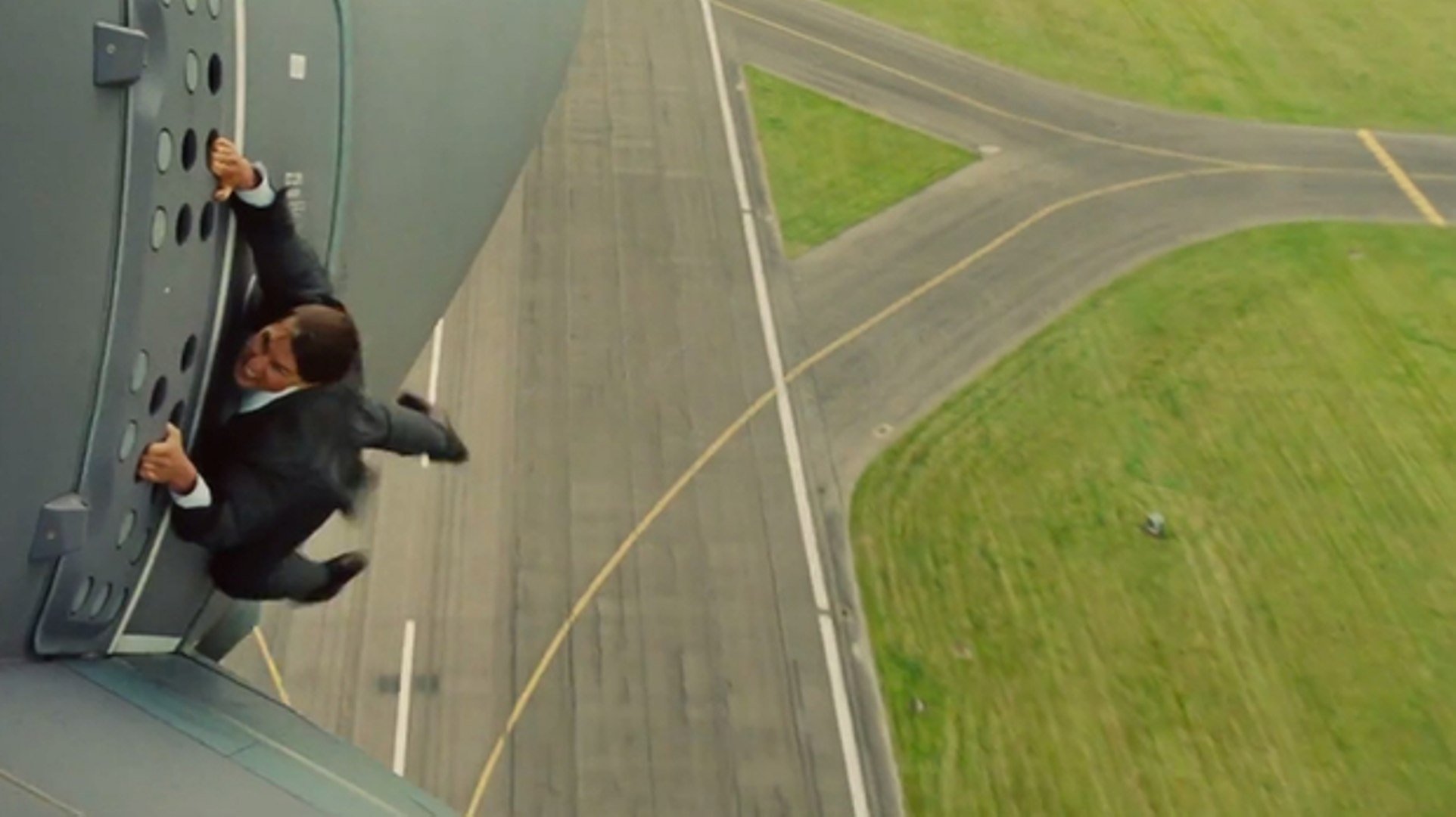 Tom Cruise clinging to the outside of an airplane in Mission: Impossible - Rogue Nation (2015)