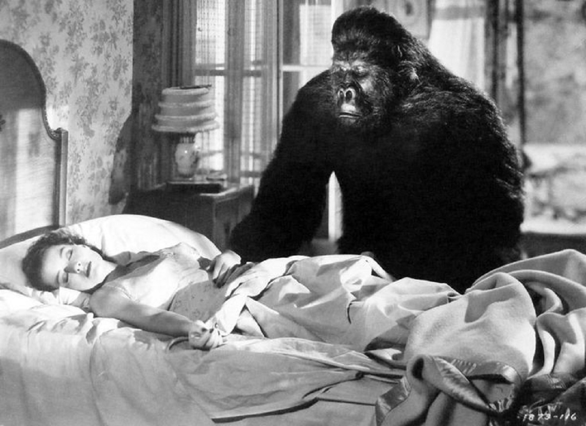The ape (Charles Gemora) looks in on the sleeping Ellen Drew in The Monster and the Girl (1941)
