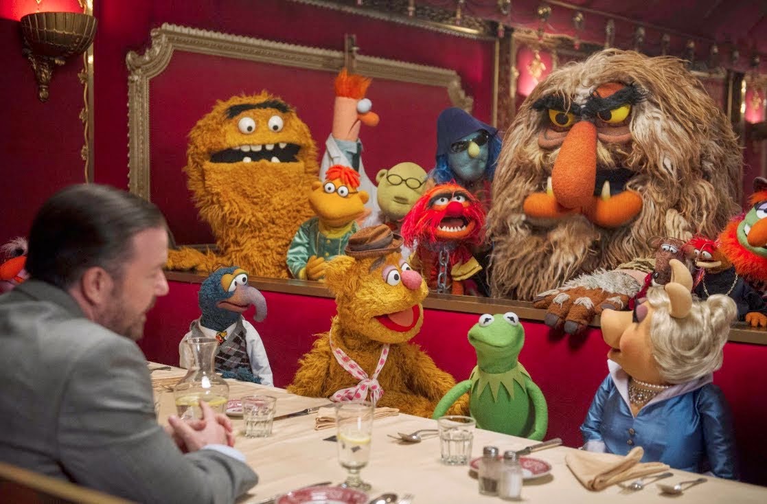 The Muppets sit down in a restaurant with manager Dominic Badguy (Ricky Gervais) in Muppets Most Wanted (2014)