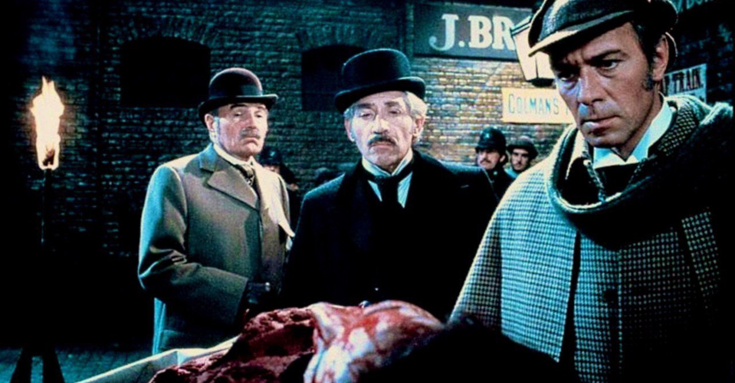 Dr Watson (James Mason) and Inspector Lestrade (Frank Finlay) look on as Sherlock Holmes (Christopher Plummer) examines a body in Murder By Decree (1979)