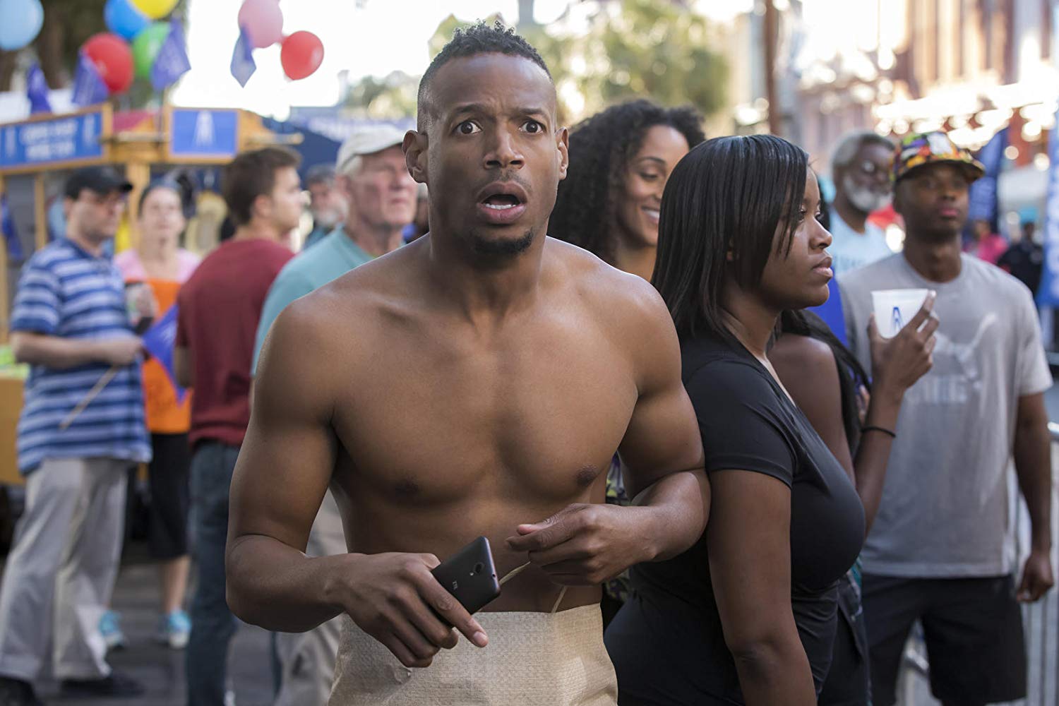 Marlon Wayans forced to make his way through a parade without any clothes in Naked (2017)