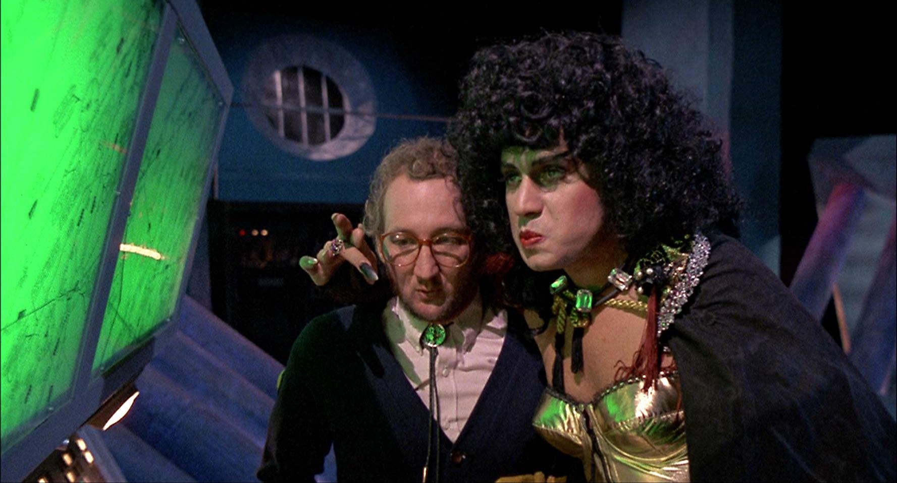 (l to r) Mad scientist Robert Englund and the crossdressing super-villain Velvet Von Ragnar (Gene Simmons) in Never Too Young to Die (1986)