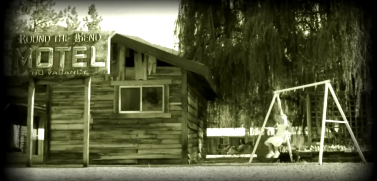 The Round the Bend motel and ghost girl on the swing in No Tell Motel (2013)