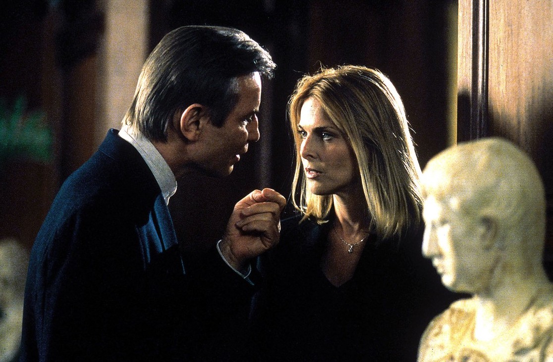 Stone Alexander (Michael York) menaces Cassandra Barashe (Catherine Oxenberg) in The Omega Code (1999)