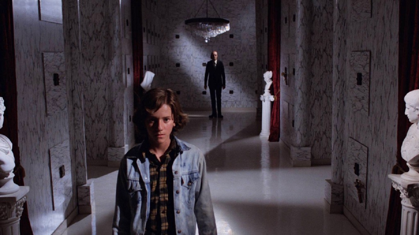 Young Michael Baldwin ventures into the Morningside Mortuary while The Tall Man (Angus Scrimm) lurks in the background in Phantasm (1979)