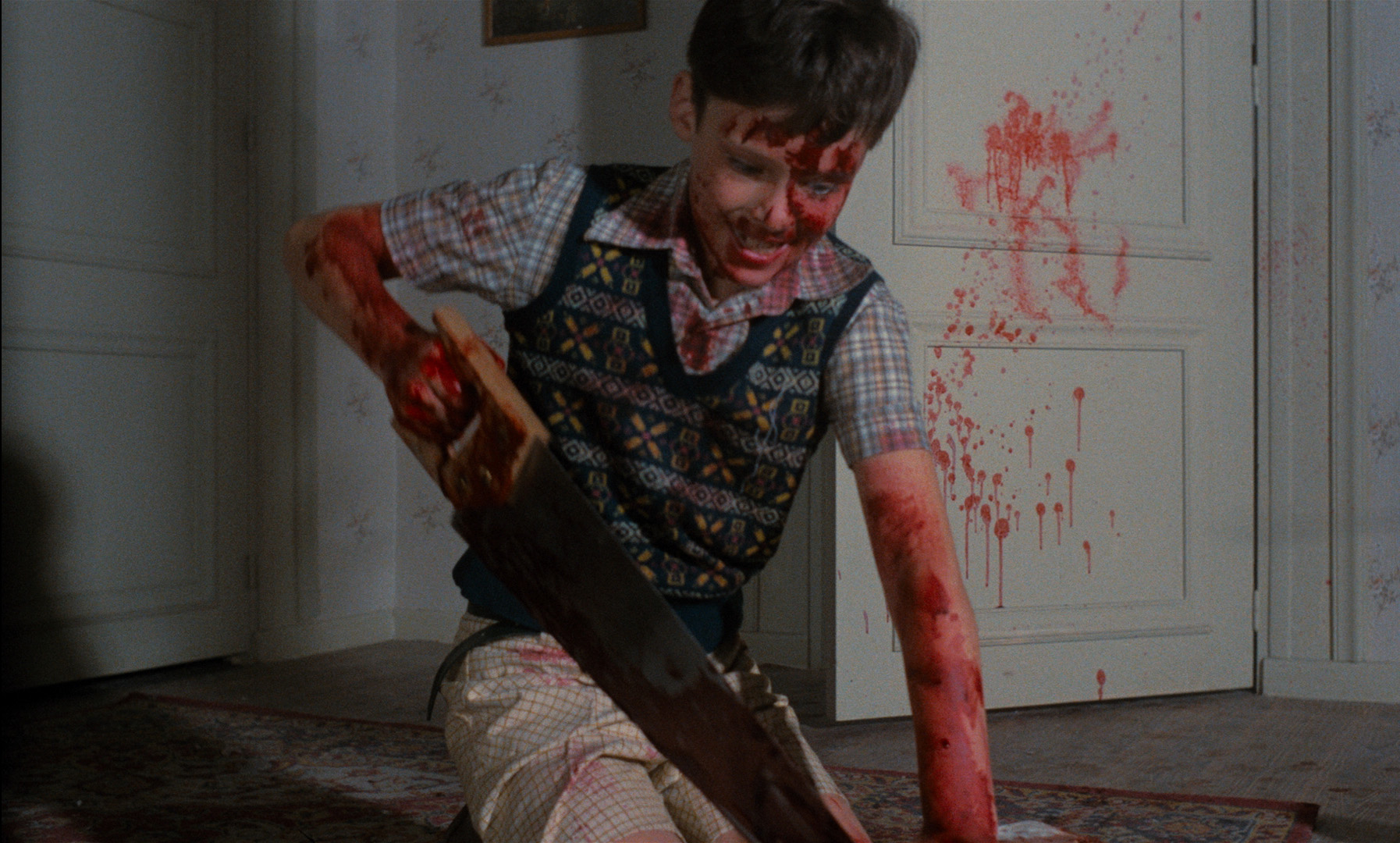 The young killer hacks up his mother's body in Pieces (1983)