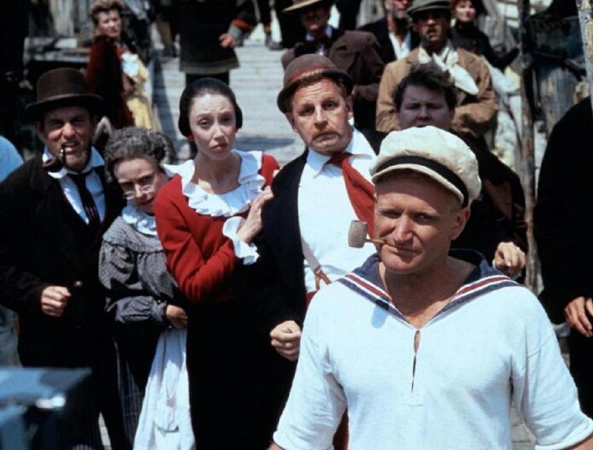 Popeye (Robin Williams) (front right) with Wimpy (Paul Dooley) and Olive Oyl (Shelley Duvall) to his left in Popeye (1980)