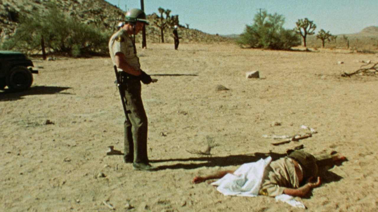 Law enforcement stand over a dead protestor in Punishment Park (1971)