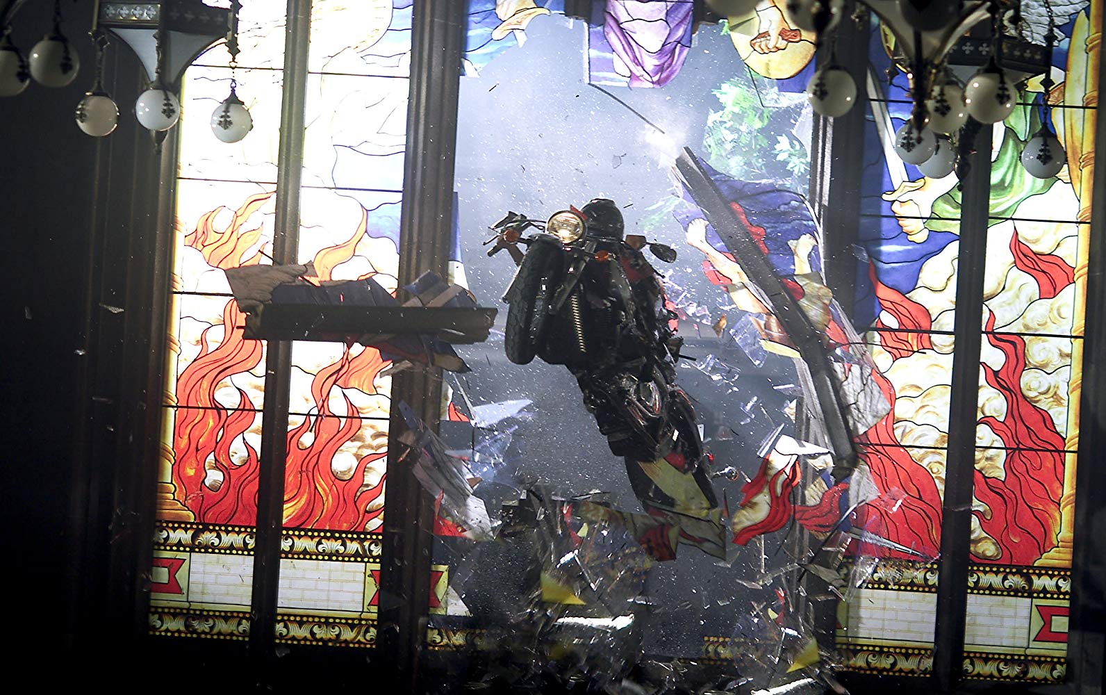 Alice (Milla Jovovich) rides a motorcycle through a stained glass window in Resident Evil: Apocalypse (2004)