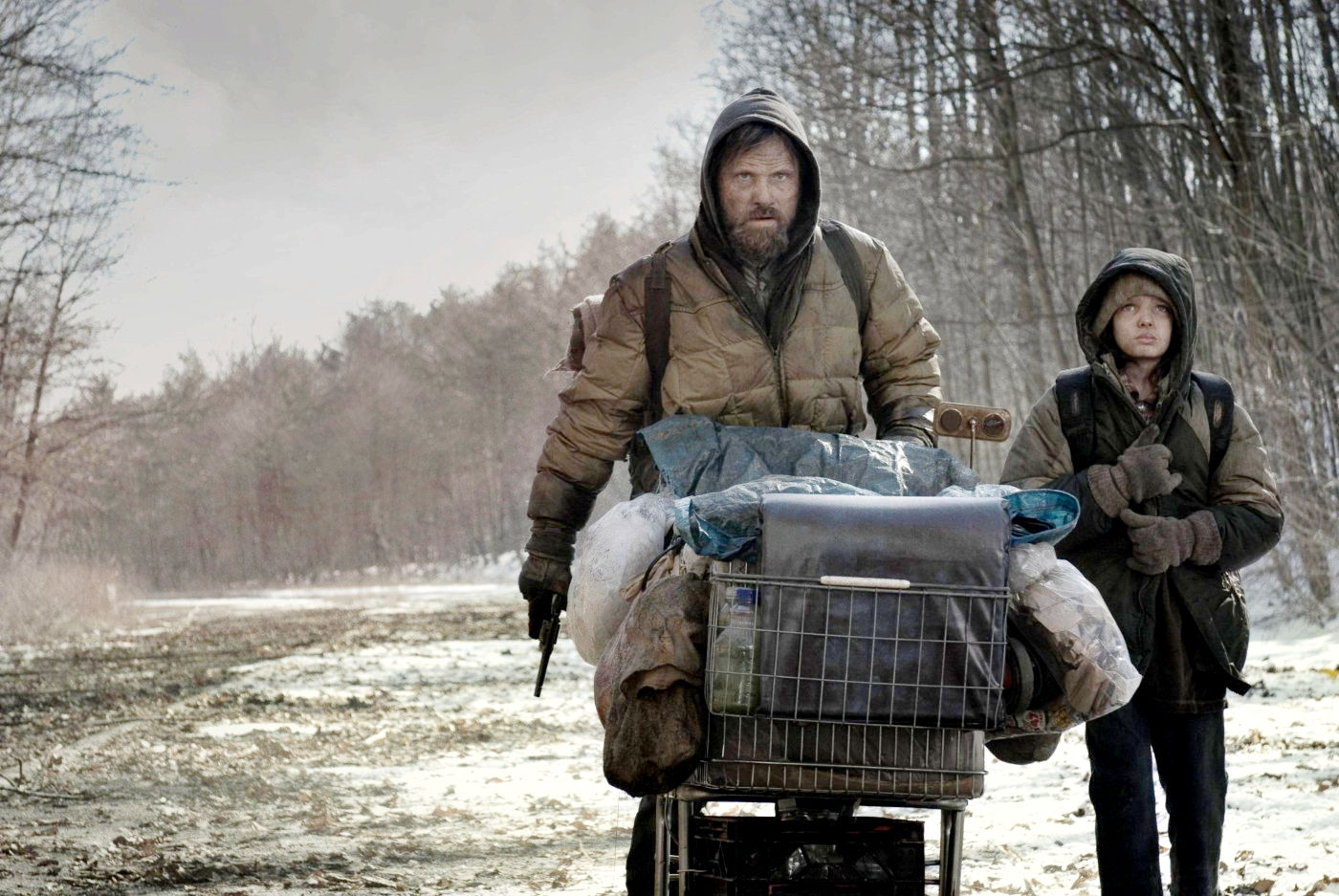 The Man (Viggo Mortensen) and Boy (Kodi Smit-McPhee) make their way across the post-apocalyptic landscape in The Road (2009)