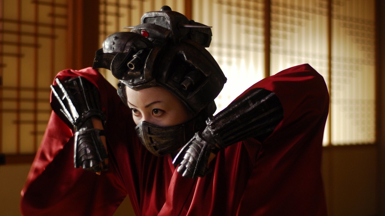 Cyborg geisha Yoshie (Aya Kiguchi) goes into action with her head-mounted machine gun in Robo-Geisha (2009)