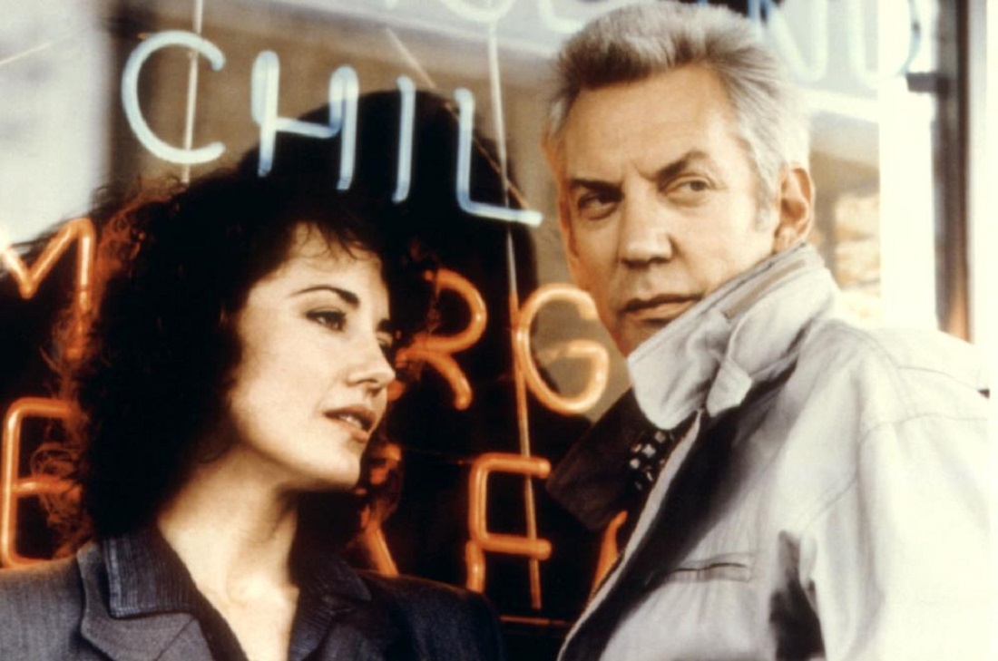 Journalist Belinda Balaski and Catholic priest Donald Sutherland team up to stop a killer in The Rosary Murders (1987)