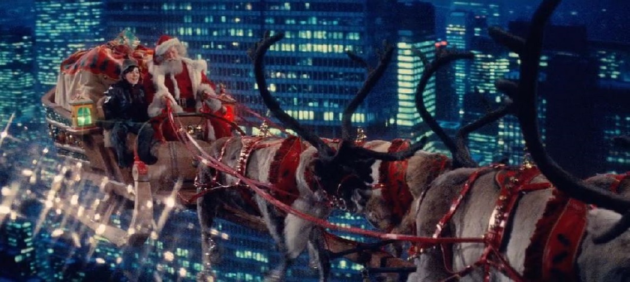 Santa Claus (David Huddleston) flies through the New York skies by reindeer along with Christian Fitzpatrick in Santa Claus - The Movie (1985)