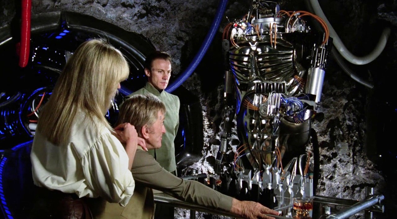 (l to r) Alex (Farrah Fawcett) and Adam (Kirk Douglas) sit down to play chess as Benson (Harvey Keitel) unveils his robot Hector in Saturn 3 (1980)