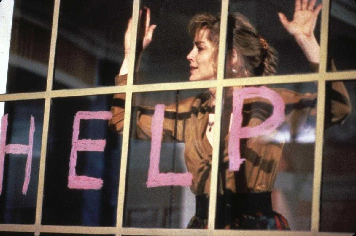 A young unknown Sharon Stone trapped inside the apartment in Scissors (1991)