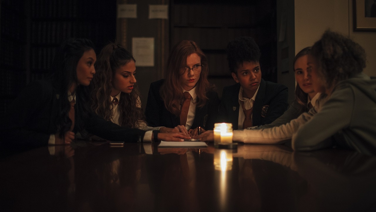 The girls prepare to conduct a seance - Stephanie Sy, Inanna Sarkis, Madisen Beaty, Djouliet Amara, Suki Waterhouse and Ella-Rae Smith in Seance (2021)