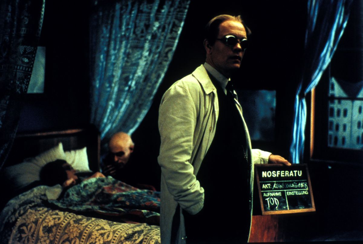 John Malkovich as F.W. Murnau (front) directs while Willem Dafoe's Max Schreck feeds on leading lady Catherine McCormack in the background in Shadow of the Vampire (2000)