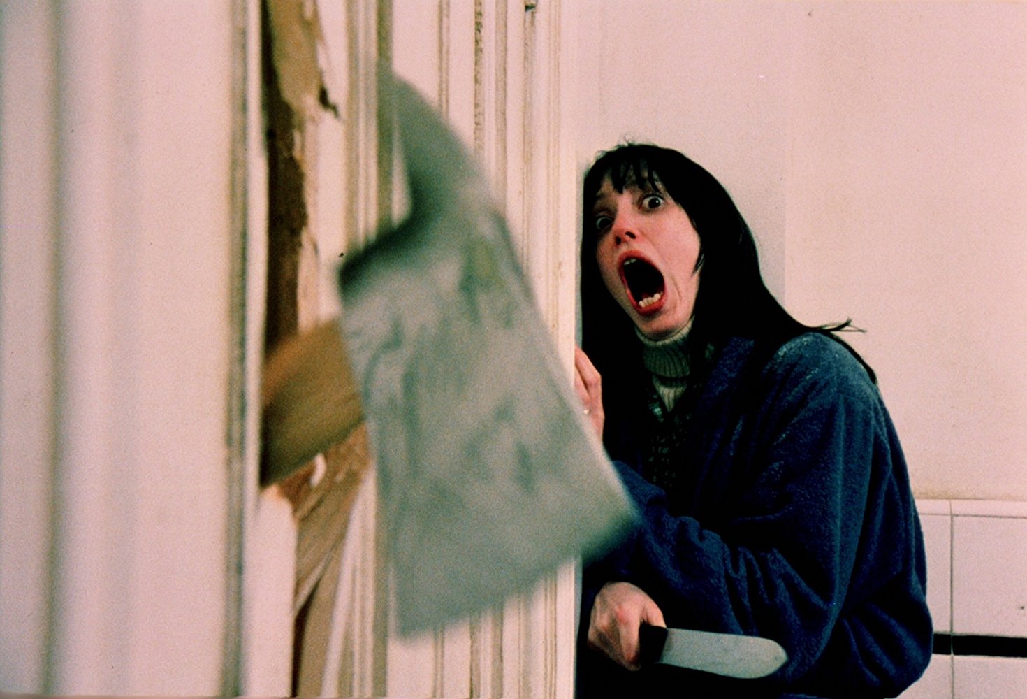 Shelley Duval facing an axe through the door in The Shining (1980)