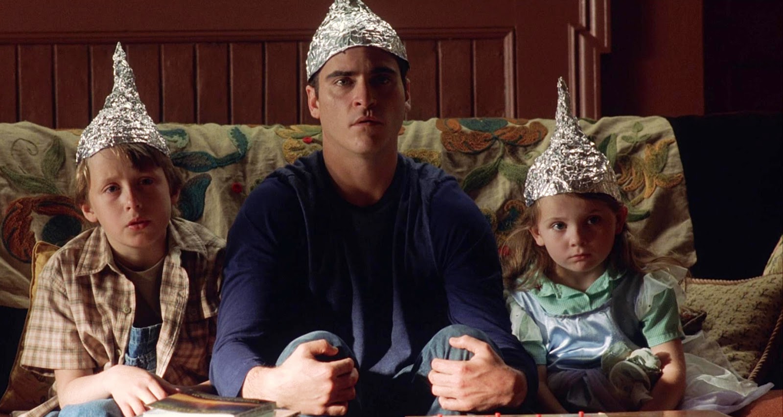 Joaquin Phoenix and the two children Rory Culkin and Abigail Breslin greet the phenomenon with aluminium hats in Signs (2002)