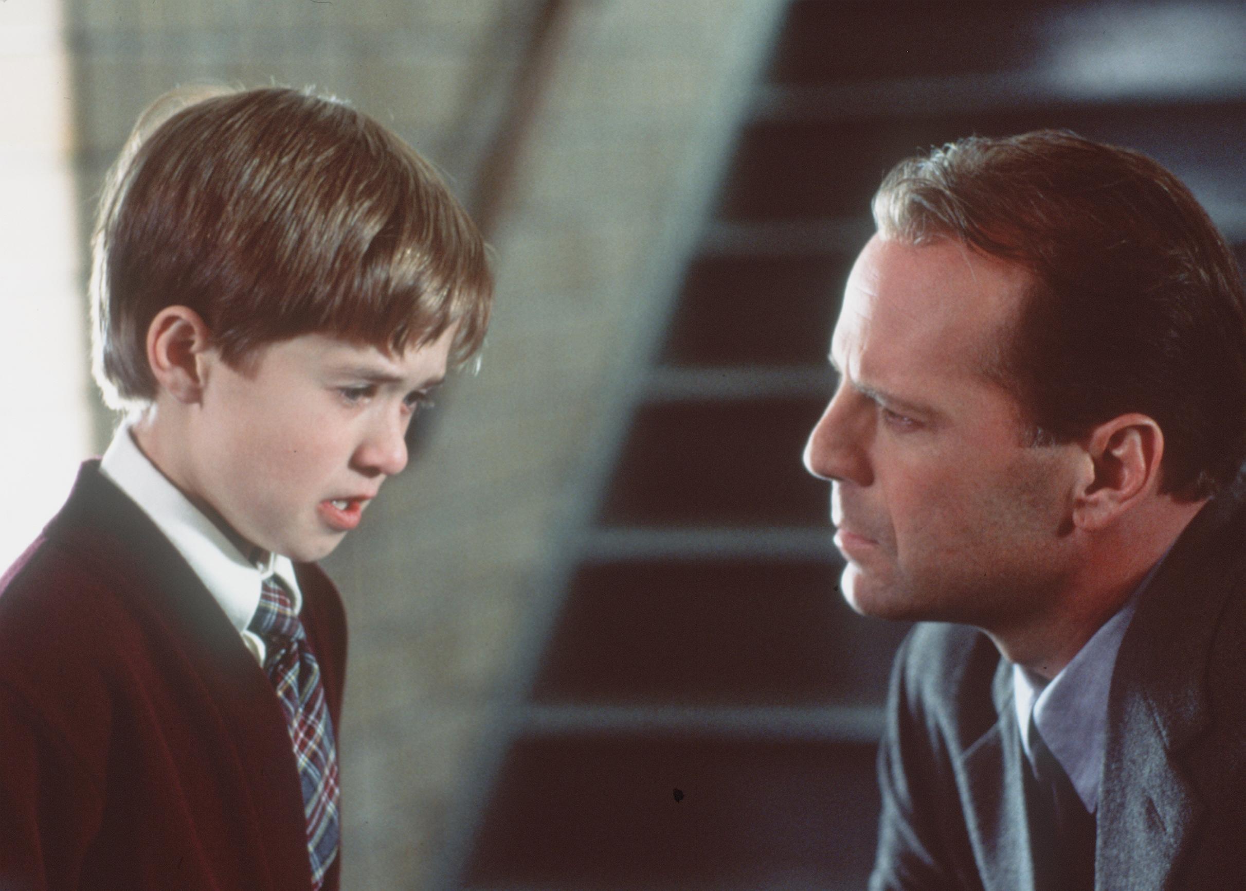 Psychologist Bruce Willis dealing with Haley Joel Osment as a child who insists he can see ghosts in The Sixth Sense (1999)