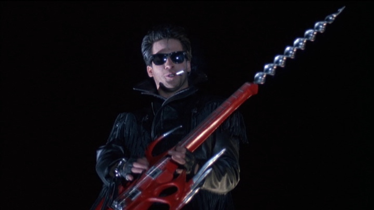 Alanas Hitch as The Driller Killer with combination electric guitar/powerdrill in Slumber Party Massacre II (1987)