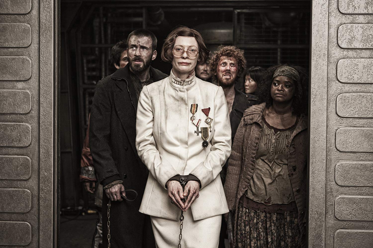 The revolutionaries - Chris Evans, Ewen Bremner, Ko Asung and Octavia Spencer - head to the forward compartments with an imprisoned Minister Mason (Tilda Swinton) in Snowpiercer (2013)