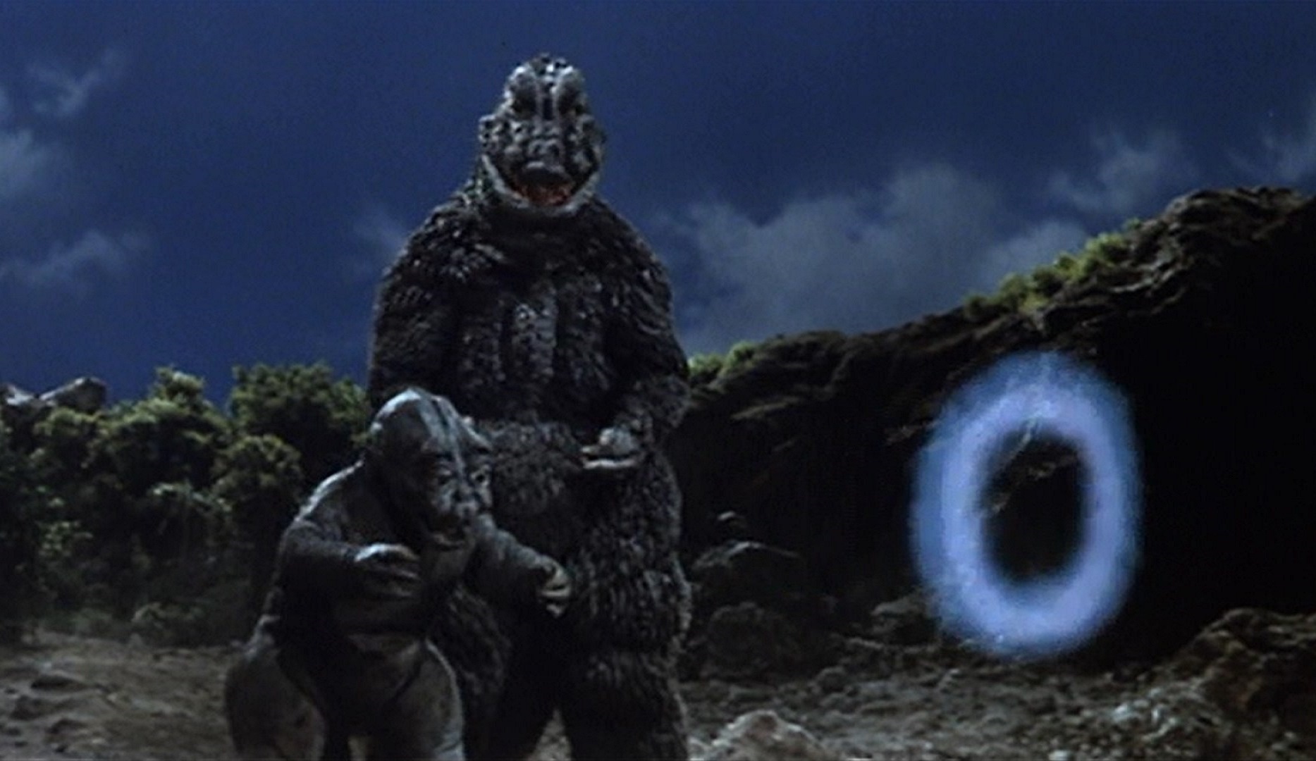 Godzilla with son Minya who finds he can only blow smoke rings instead of radioactive fire in Son of Godzilla (1968)