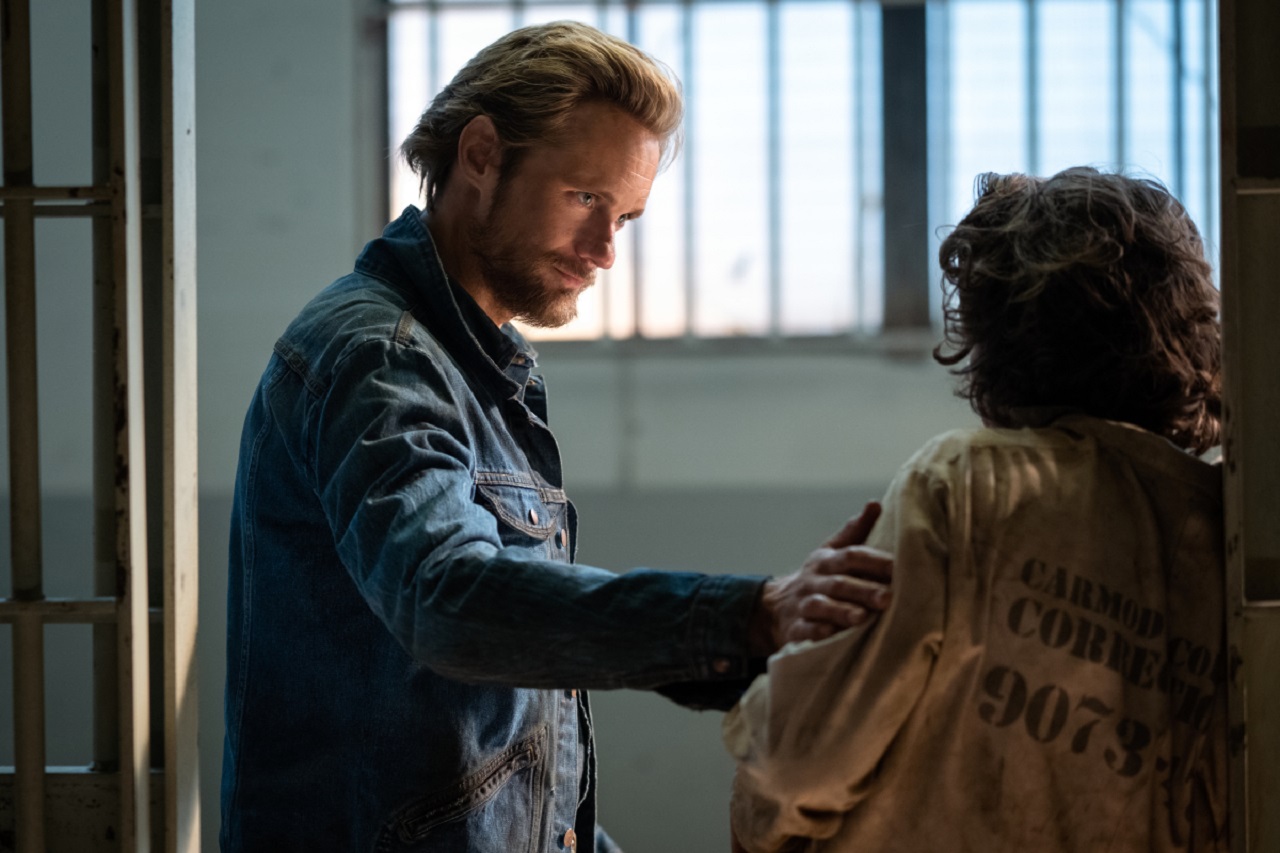 Randall Flagg (Alexander Skarsgård) greets Lloyd Henried (Nat Wolff) in jail in The Stand (2020-1)