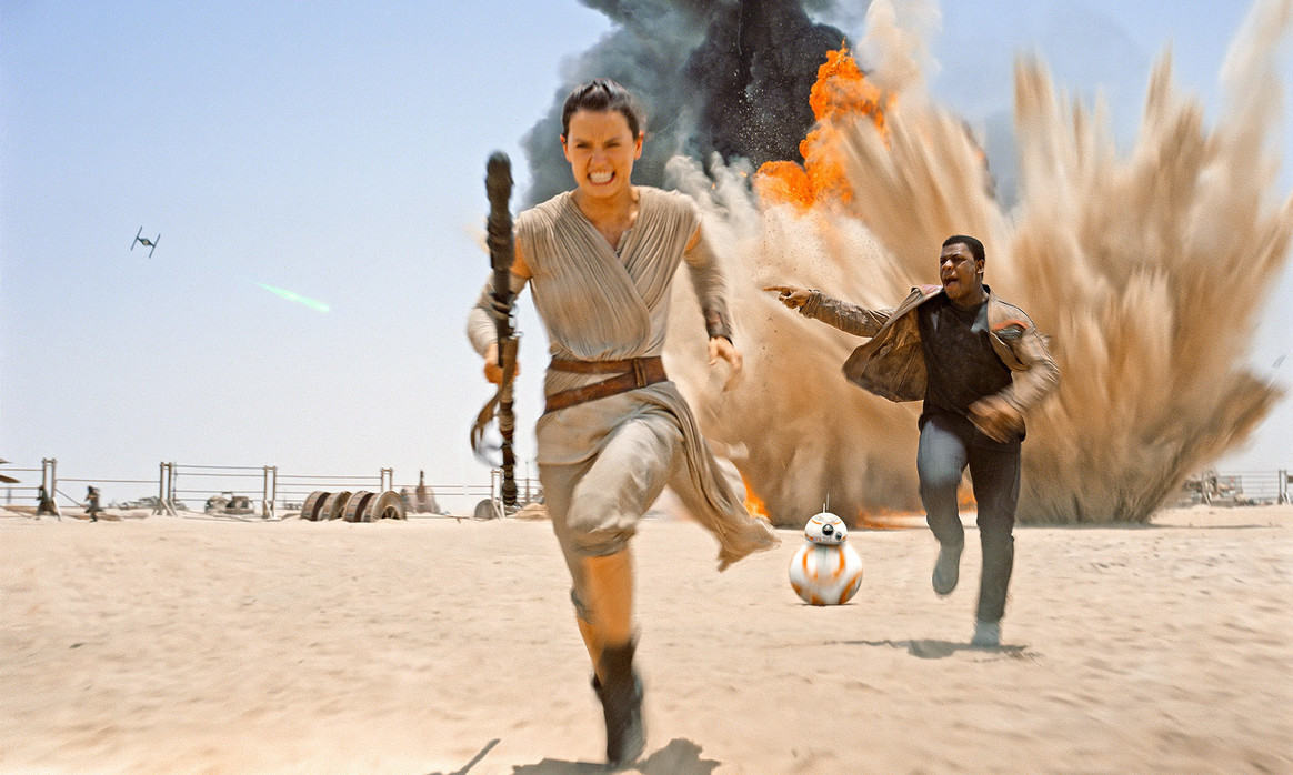 Rey (Daisy Ridley) and Finn (John Boyega) flee an explosion in Star Wars Episode VII The Force Awakens (2015)