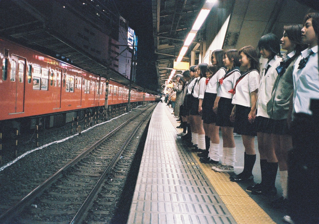 Japanese schoolgirls lined up on a railway platform to commit mass suicide in Suicide Club (2002)