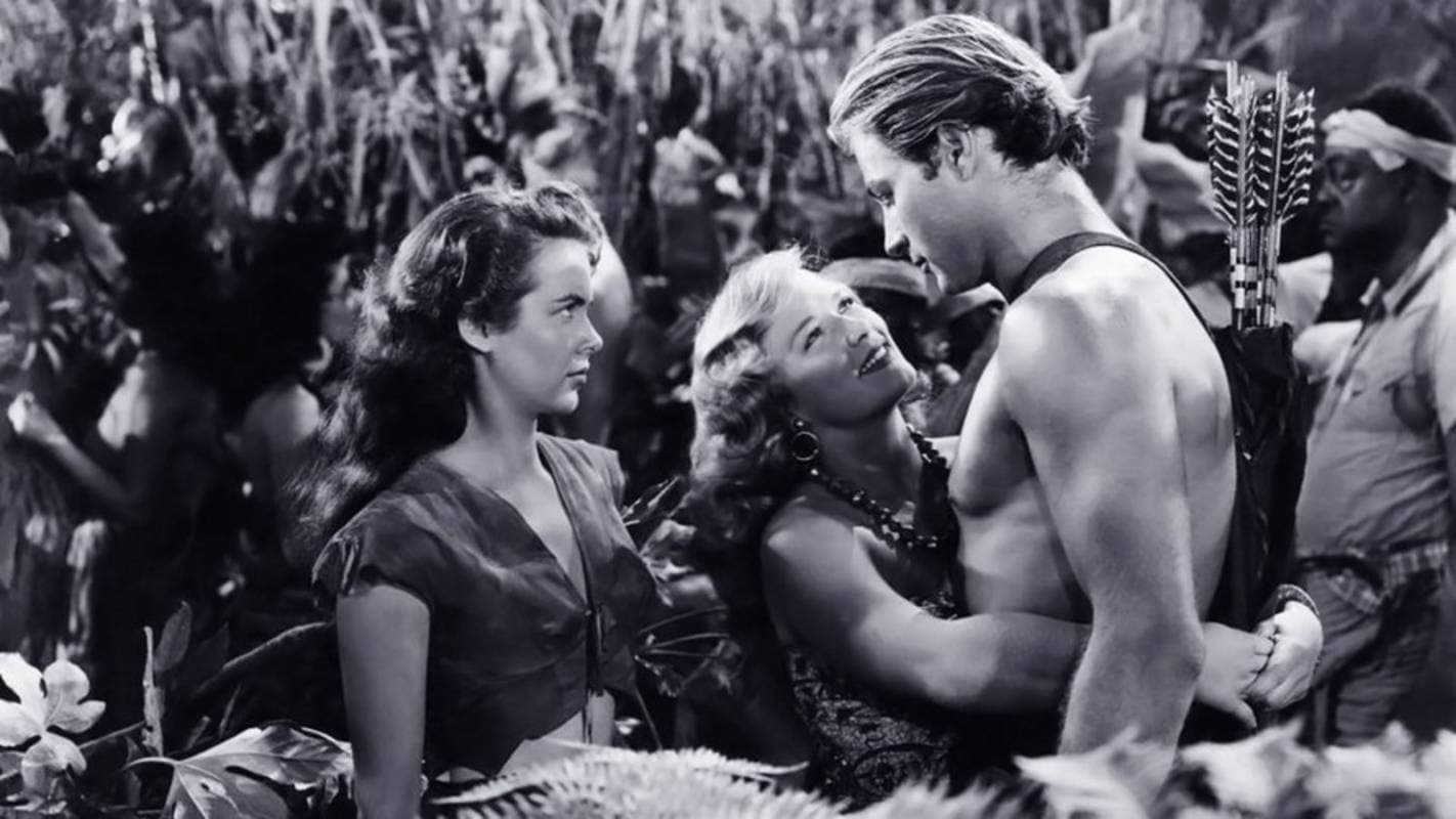 A none-too-happy Jane (Vanessa Brown) looks on as Lola (Denise Darcel) hugs Tarzan (Lex Barker) in Tarzan and the Slave Girl (1950)