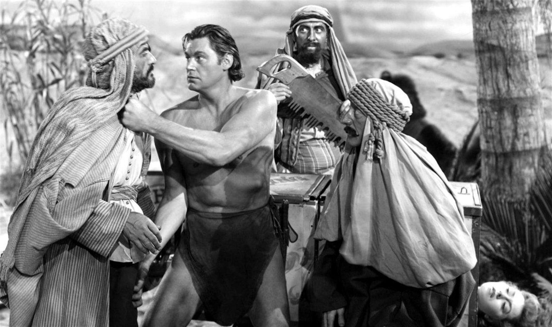 Tarzan (Johnny Weissmuller) takes on various locals to save an unconscious Nancy Kelly in Tarzan's Desert Mystery (1943)