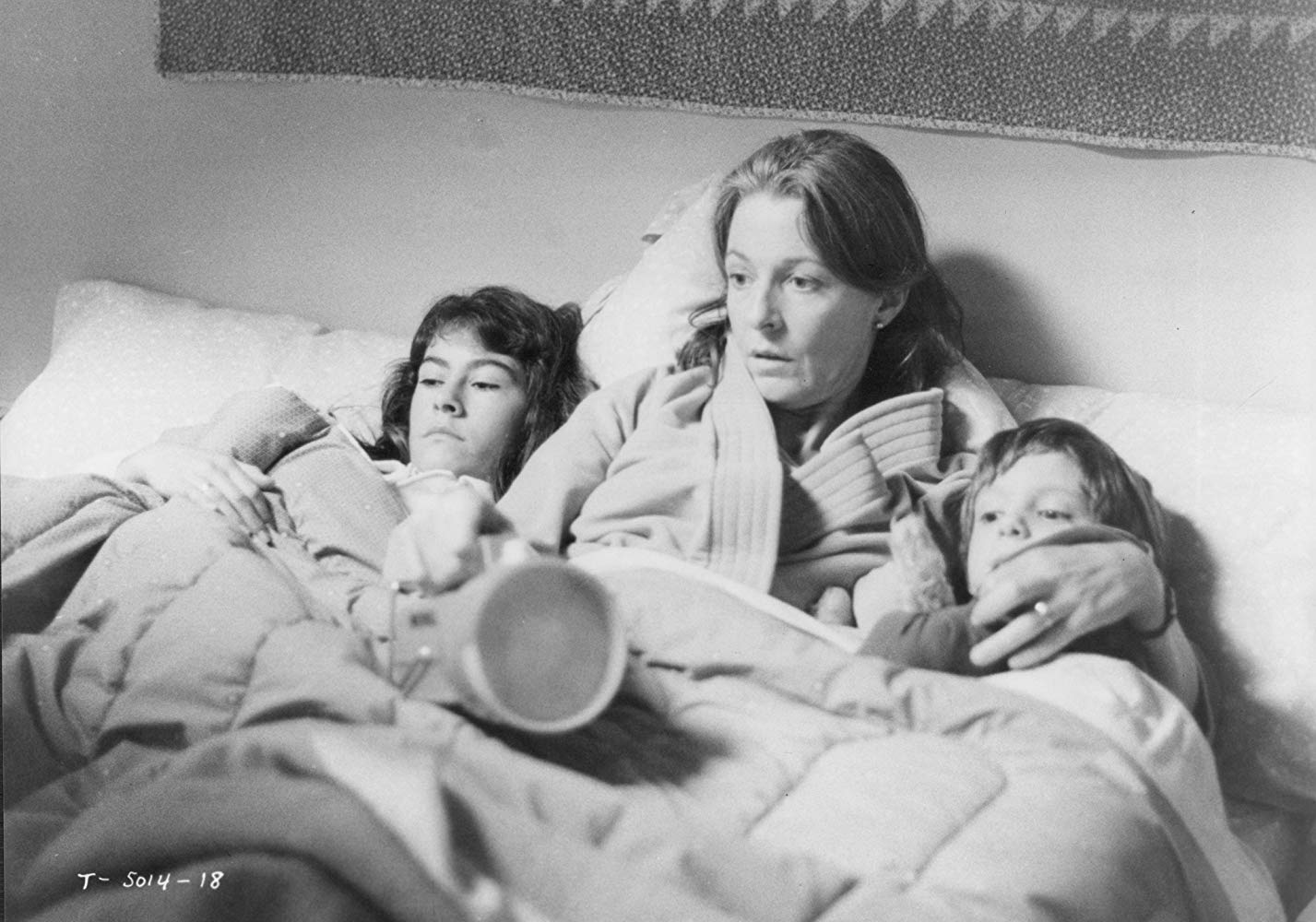 Mother Jane Alexander (c) huddles in bed with daughter Roxana Zal (l) and son Lukas Haas (r) in Testament (1983)