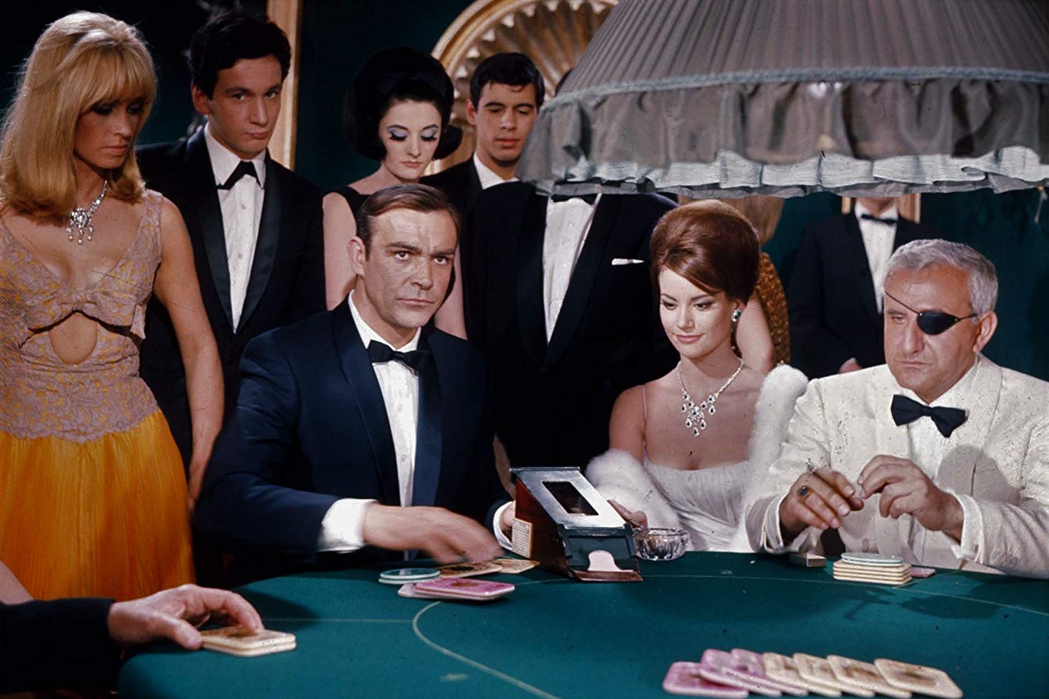 (l to r) James Bond (Sean Connery) sits down at the casino table alongside Domino (Claudine Auger) and Emilio Largo (Adolfo Celi) in Thunderball (1965)