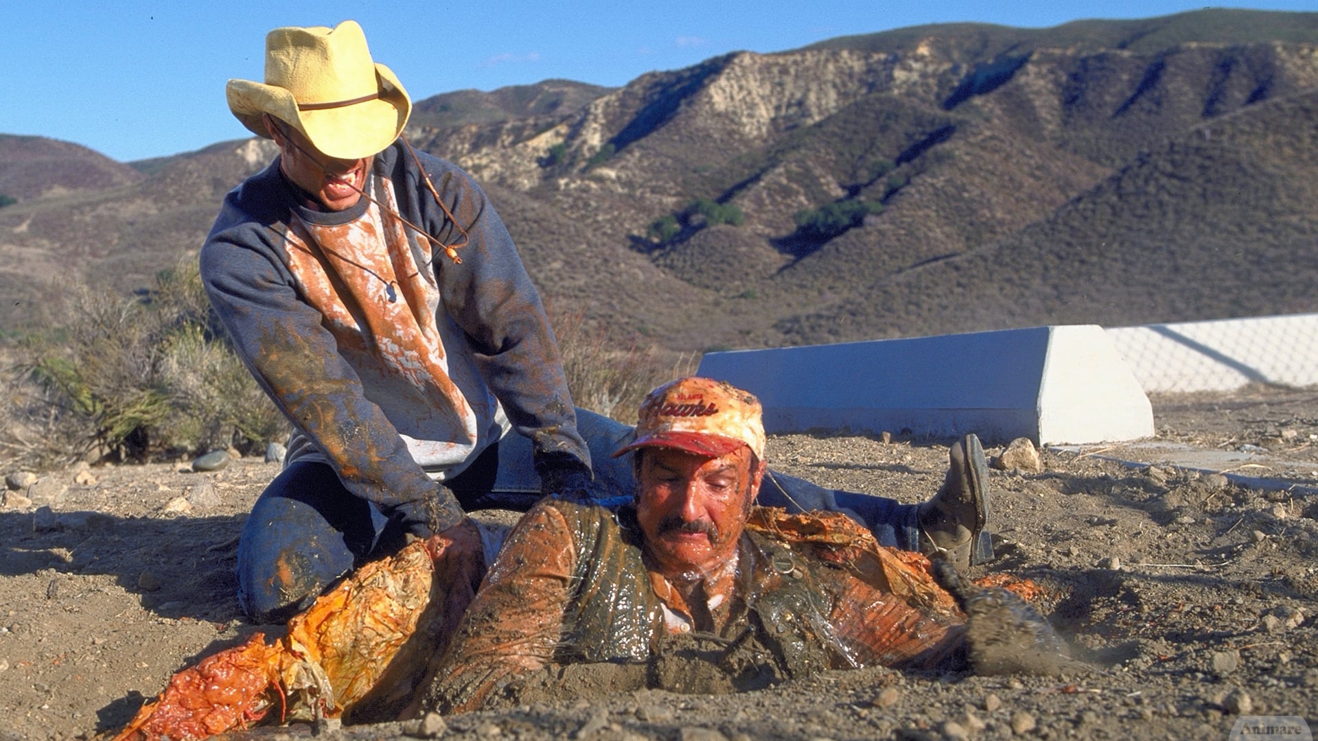 Shawn Christian tries to rescue Michael Gross from being swallowed by a Graboid in Tremors 3: Back to Perfection (2001)