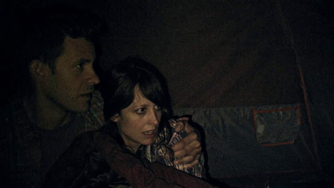 Bryce Johnson and Alexie Gilmore huddle frightened in their tent in Willow Creek (2013)