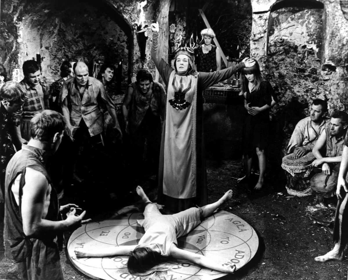 The witches conduct their ritual as the group's leader Kay Walsh (c) stands over a sacrificial Ingrid Brett in The Witches (1966)