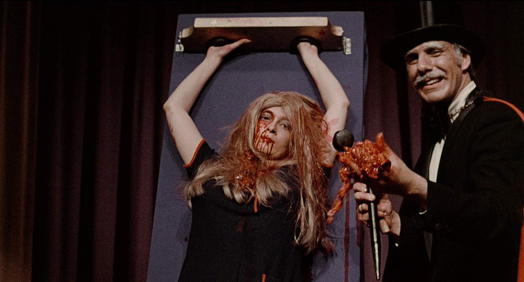Montag (Ray Sager) cuts up a woman on stage in The Wizard of Gore (1970)