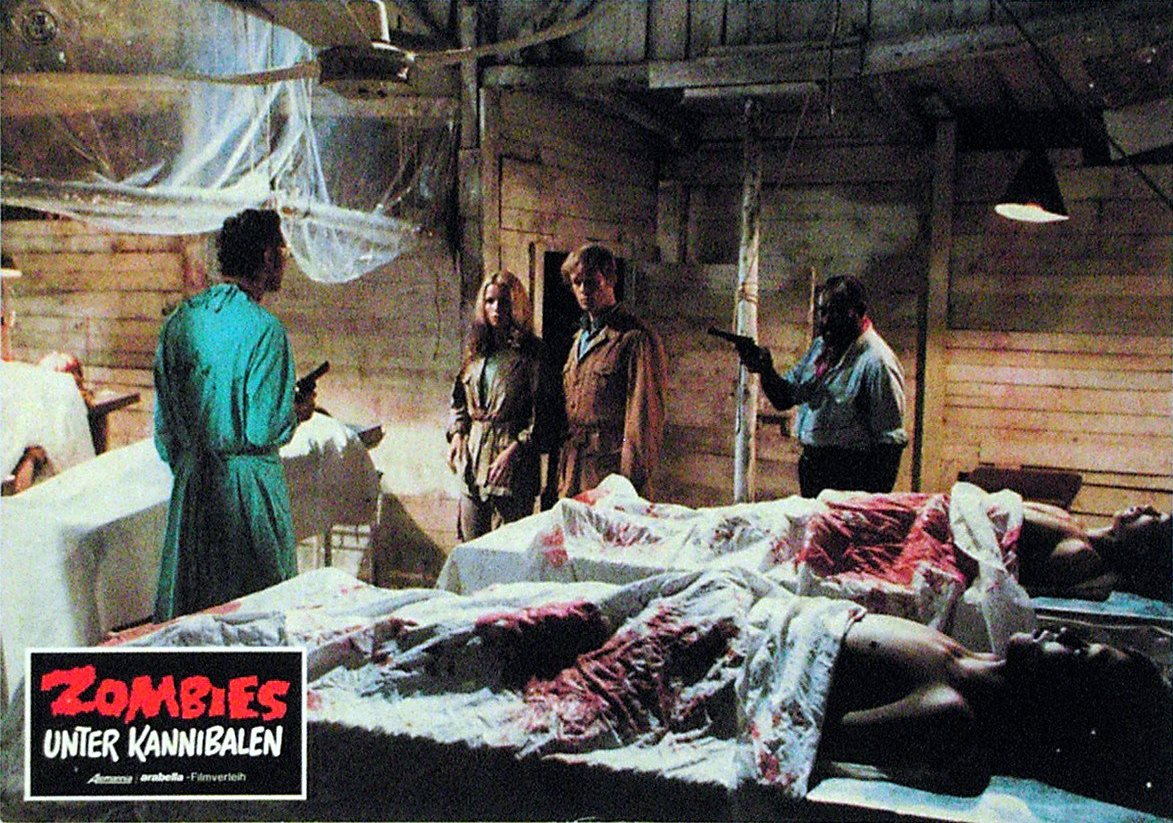 (l to r) Mad scientist Donald O’Brien amd prisoners Alexandra Delli Colli and Ian McCulloch, along with the doctor's henchman Dakar in Zombie Holocaust (1980)