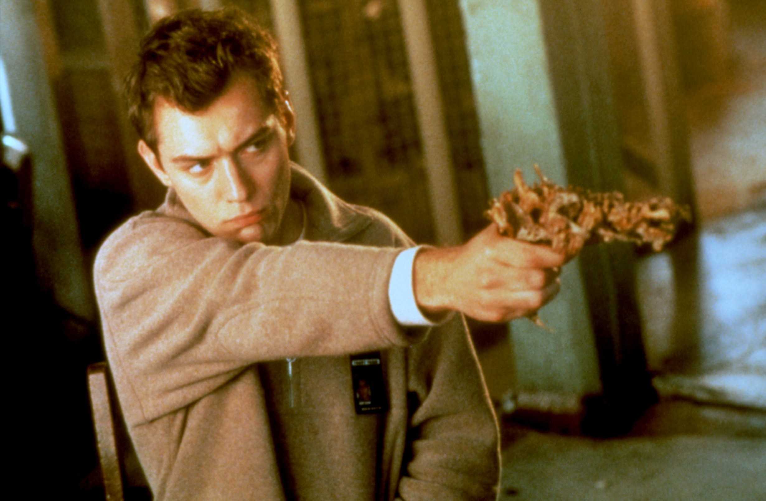 Ted Pikul (Jude Law) wields an organic gun in eXistenZ (1999)