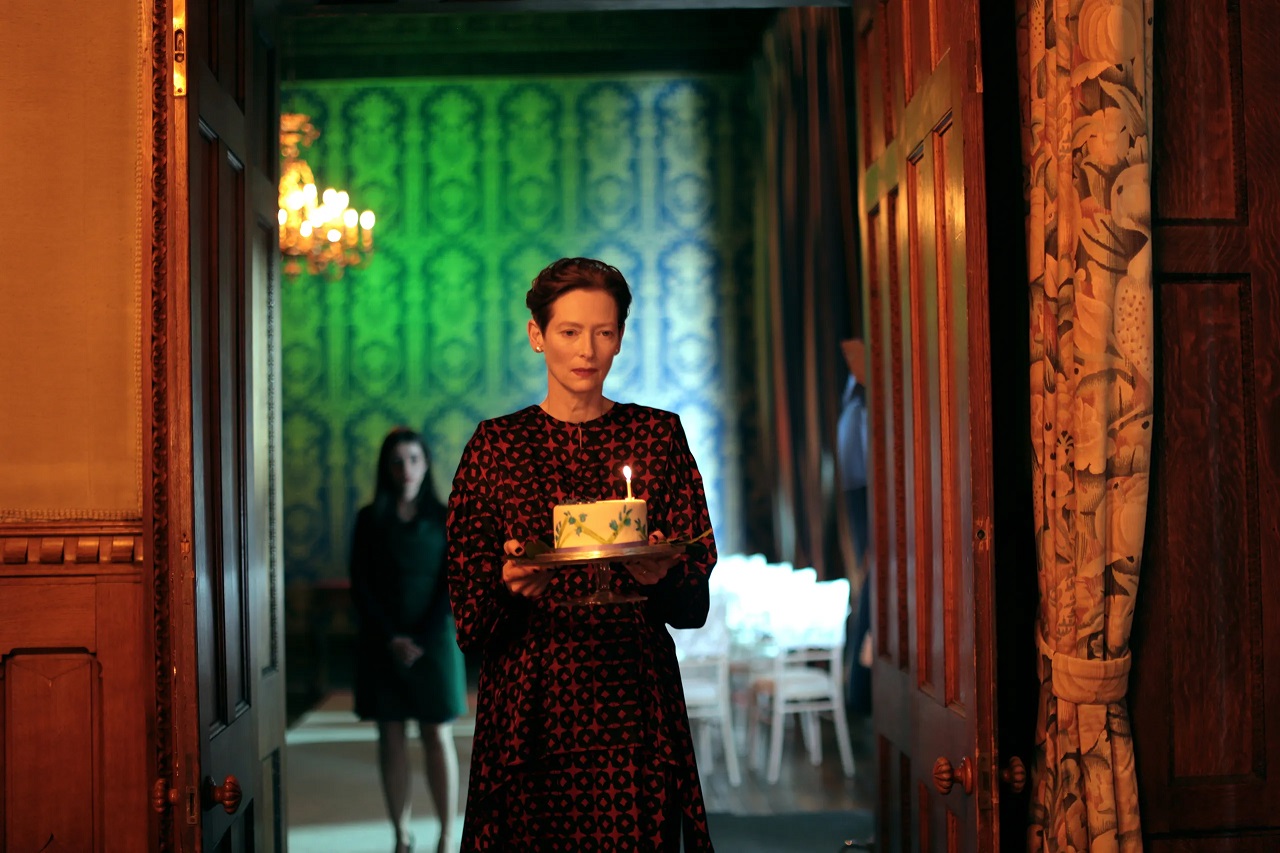 Tilda Swinton as the daughter Julie with birthday cake and receptionist Carly Sophia-Davis in The Eternal Daughter (2022)