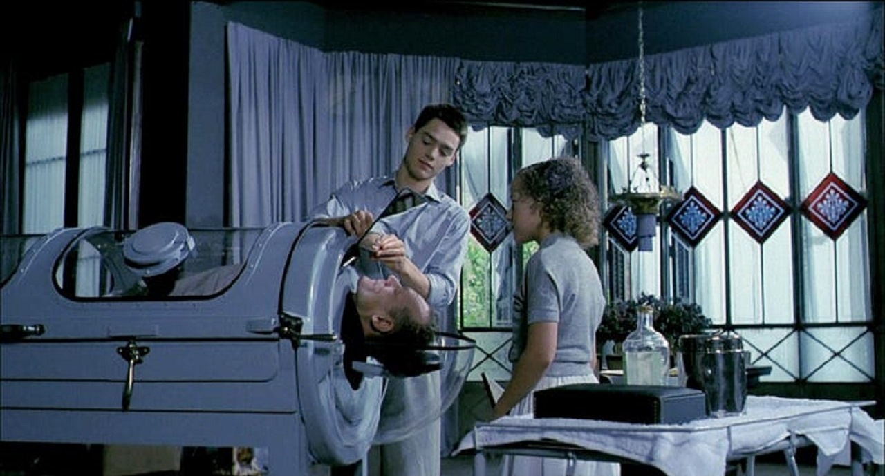 Nazi war criminal Gunter Meisner in an iron lung tended by David Sust and Gisela Eschevarria in In a Glass Cage (1986)