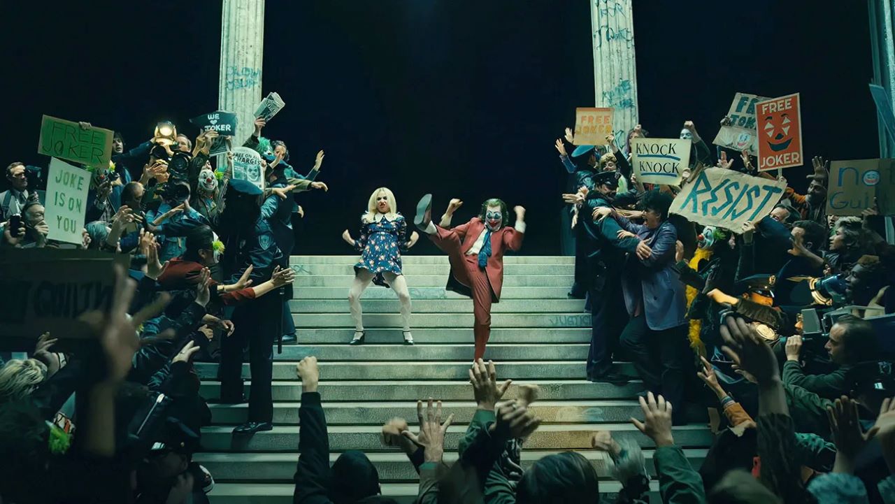 Harley Quinn (Lady Gaga) and Arthur Fleck (Joaquin Phoenix) celebrate on the courthouse steps in Joker: Folie a Deux (2024)