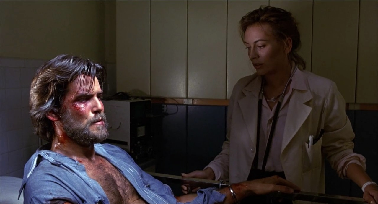 Jean-Claude Pommier (Pierce Brosnan) is tended by doctor Eileen Flax (Lesley-Anne Down) in Nomads (1986)