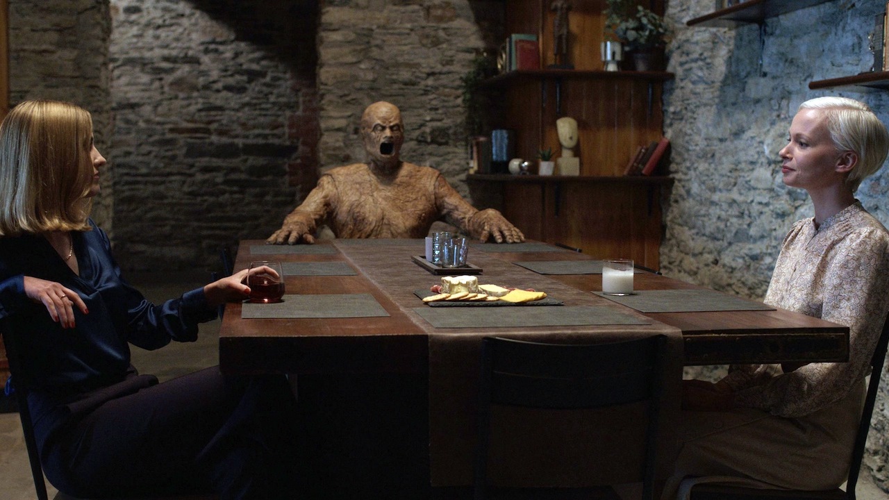 Caroline Menton and Carolyn Bracken with the wooden man in Oddity (2024)