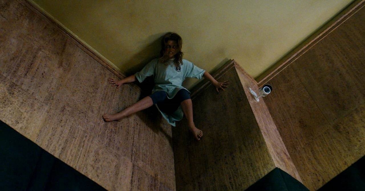 A possessed Posy Taylor climbs the wall in Prey for the Devil (2022)