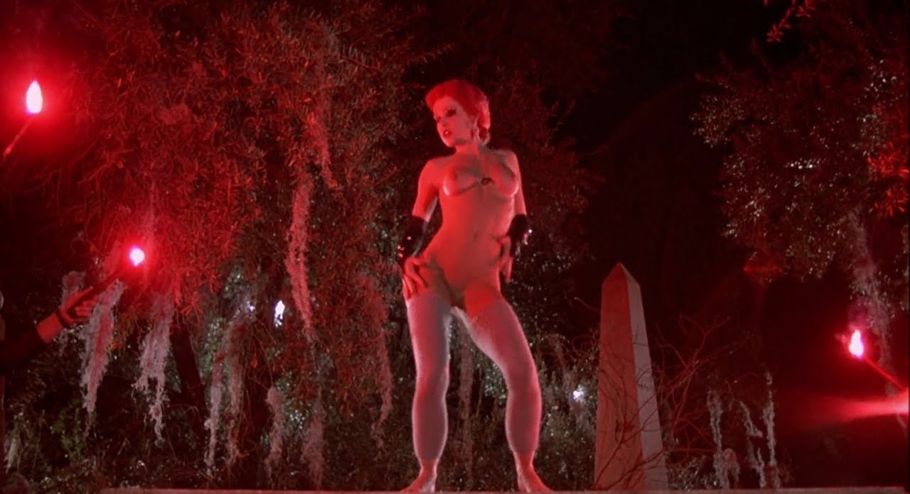 Linnea Quigley in her iconic role as trash dancing atop a gravestone in Ret...
