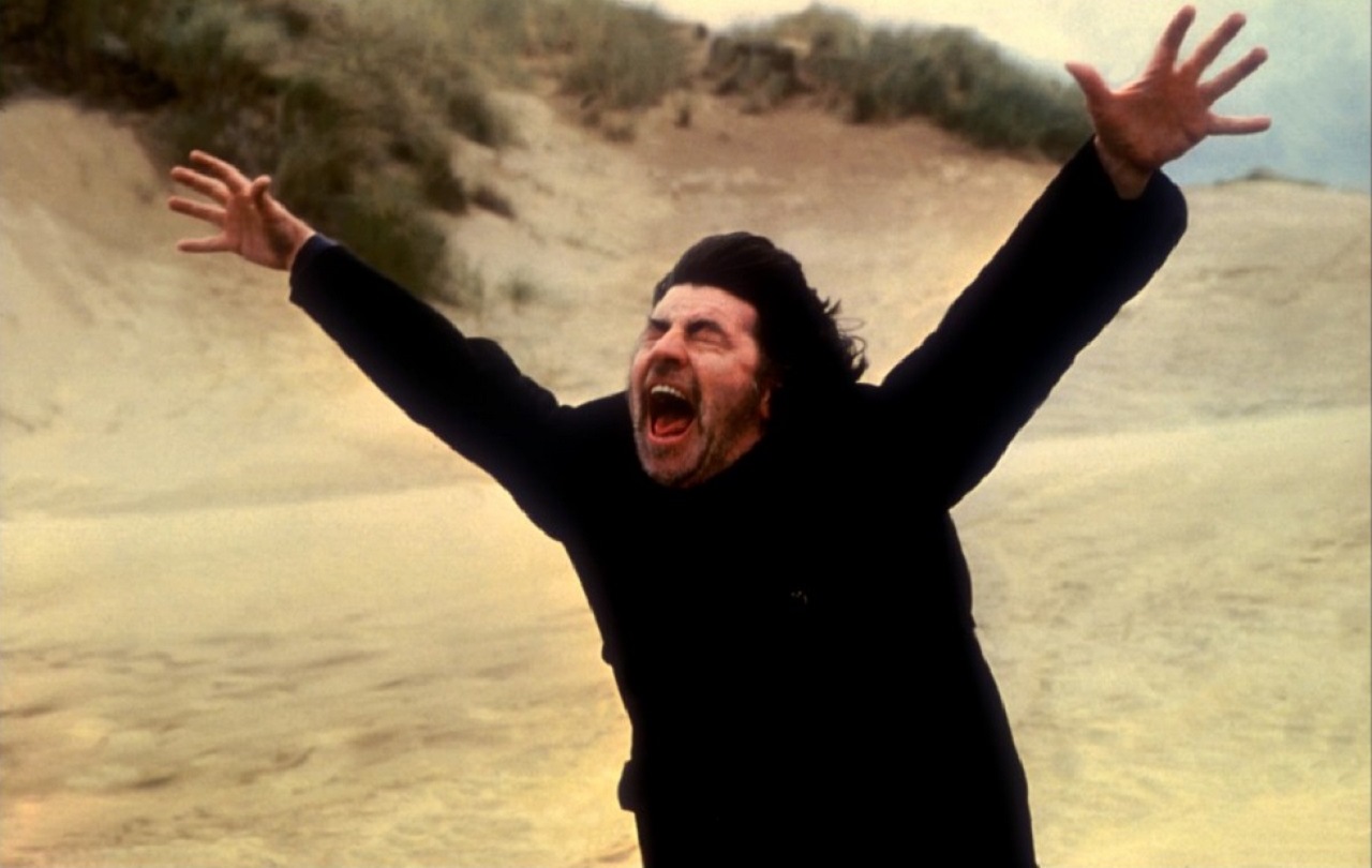 Alan Bates demonstrates the killing shout on a beach in The Shout (1978)