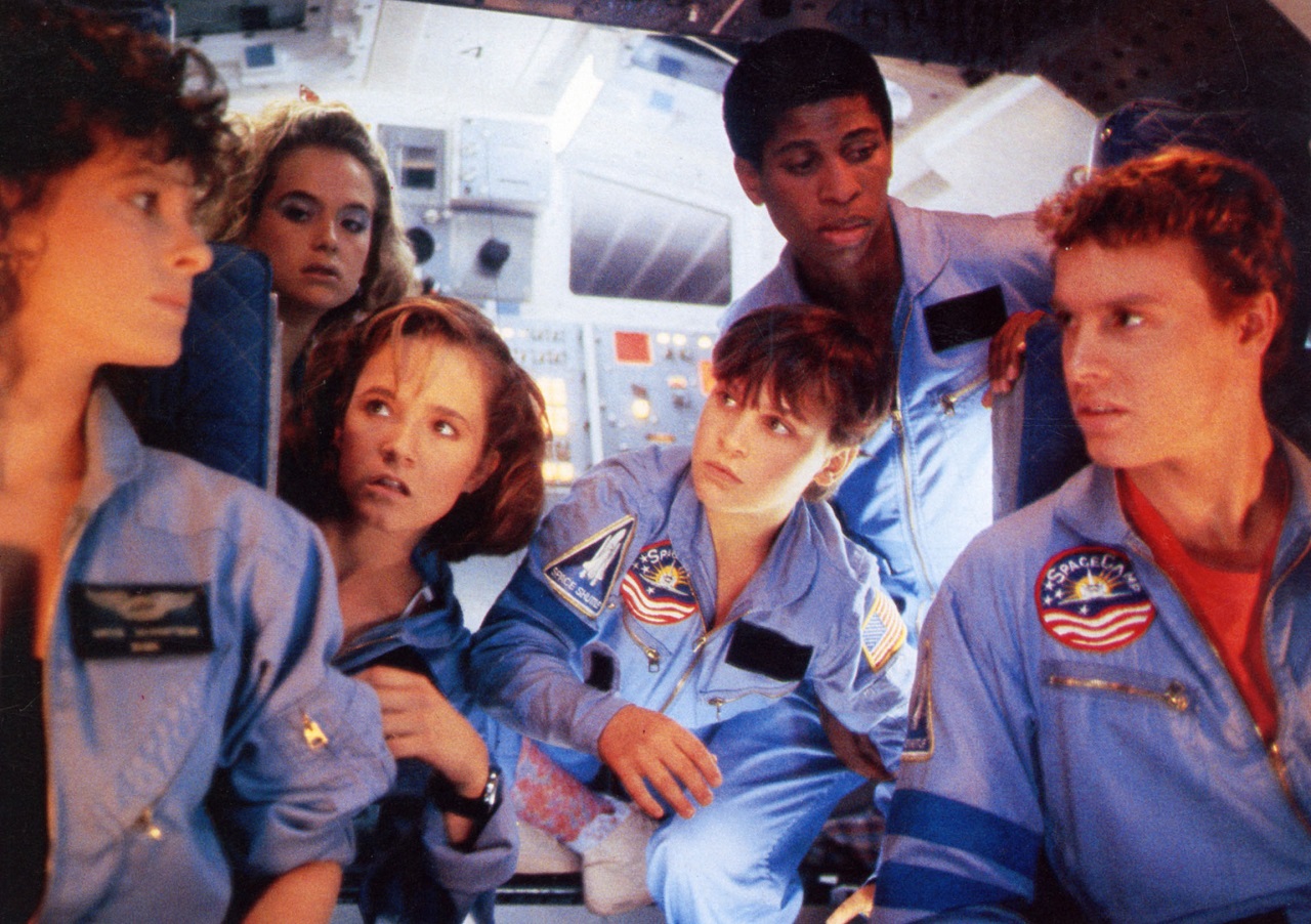 Teenagers trapped in orbit aboard the space shuttle -Kate Capshaw, Kelly Preston, Lea Thompson, Leaf (later Joaquin) Phoenix, Larry B. Scott and Tate Donovan in Spacecamp (1986)