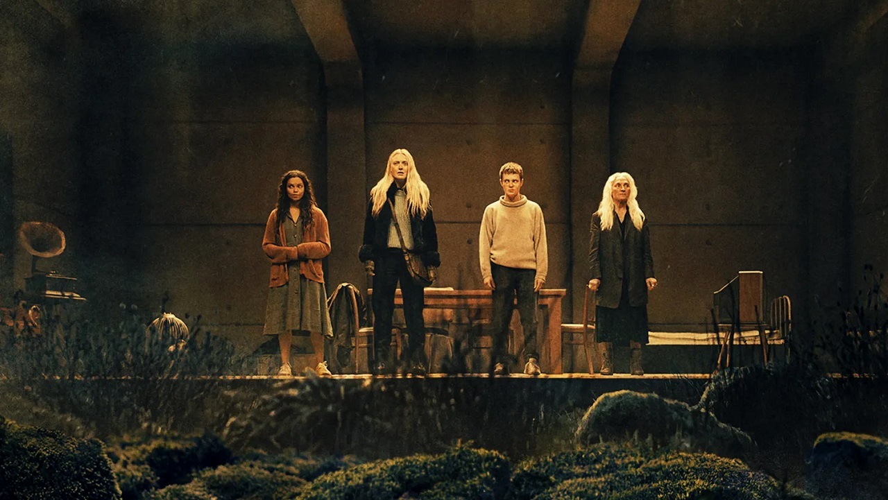 Georgina Campbell, Dakota Fanning, Oliver Finnegan and Olwen Fouere in front of the window in The Coop in The Watchers (2024)